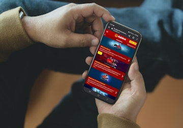 Dafabet promotions screenshot on a mobile in the hands of a man